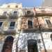 Di fronte si innalzano tre fabbricati, quasi disposti in ordine cromatico dal giallino chiaro allarancione. Presentano cornicioni decorati, timpani e ringhiere in ferro battuto